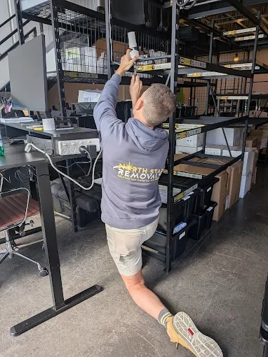 Andy reaching up to shelving during an office fit-out